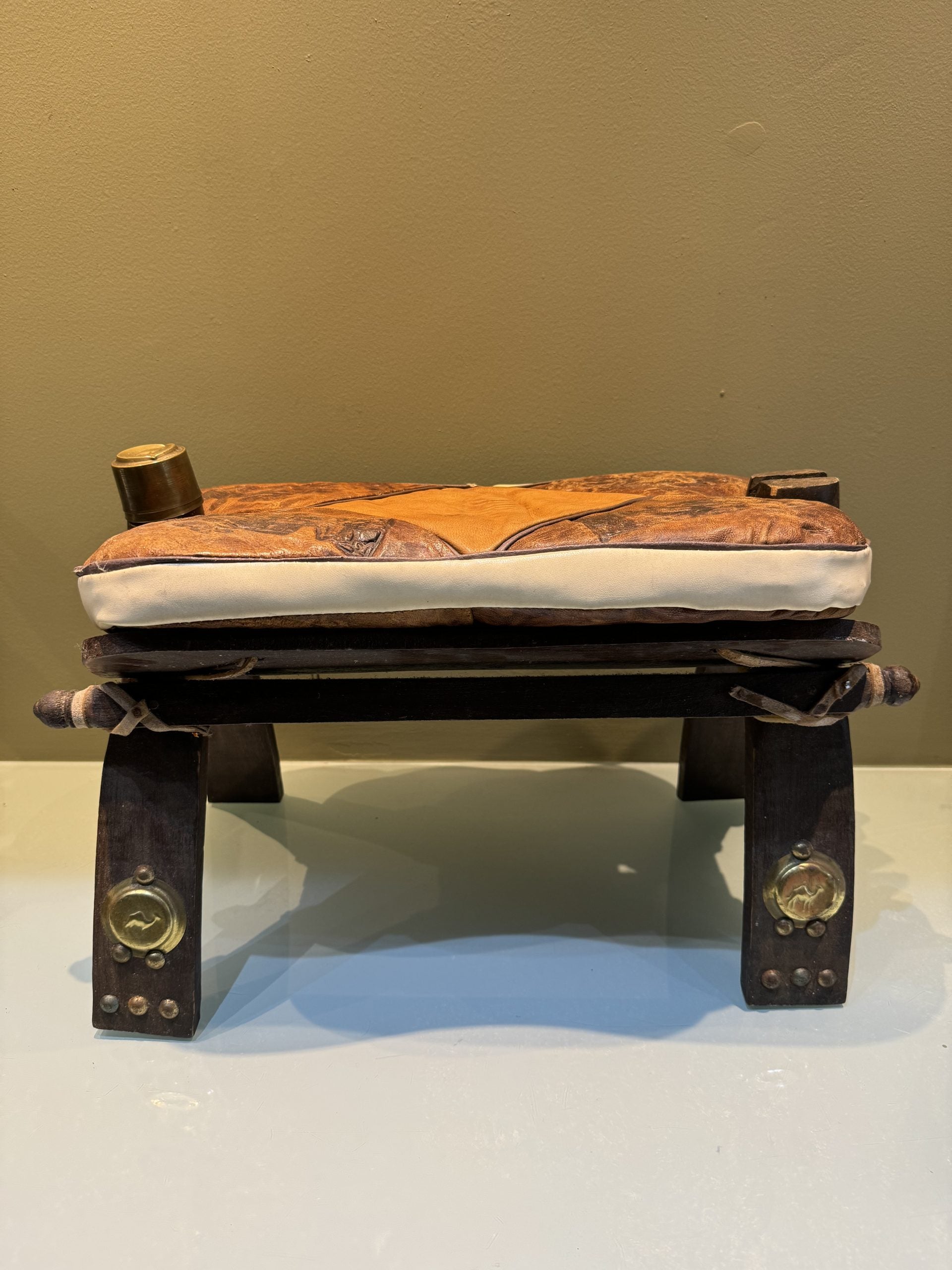 Egyptian stools, camel saddles in wood, leather and brass